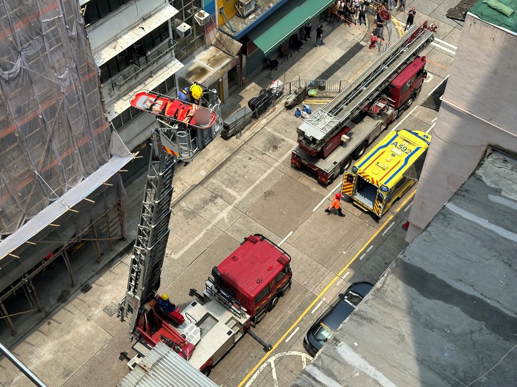 消防将女事主运往升降台再移送地面。梁国峰摄