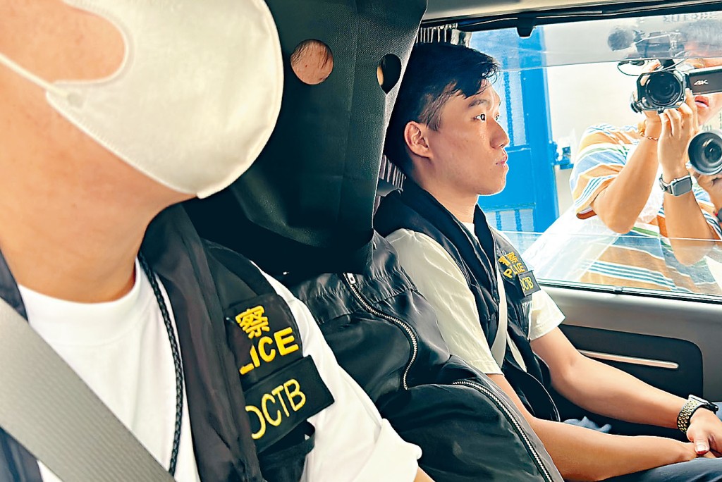 其中一名被捕疑犯由警署押返寓所搜查。