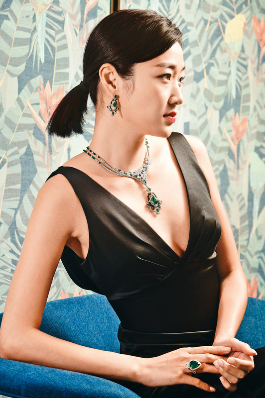 项链的设计灵感源自孔雀的羽毛，吊坠可拆下，灵活配搭。18K白色黄金配天然黑翡翠、绿宝石、蓝宝石及钻石的项链及耳环。18K白色黄金指环镶嵌绿宝石及钻石。