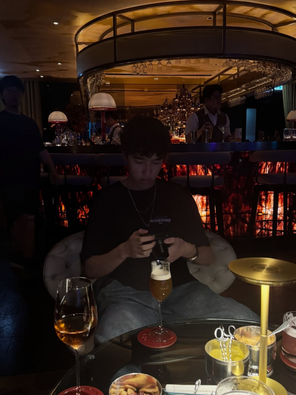 在格調優雅的酒吧中，李立仁專注地把玩相機。