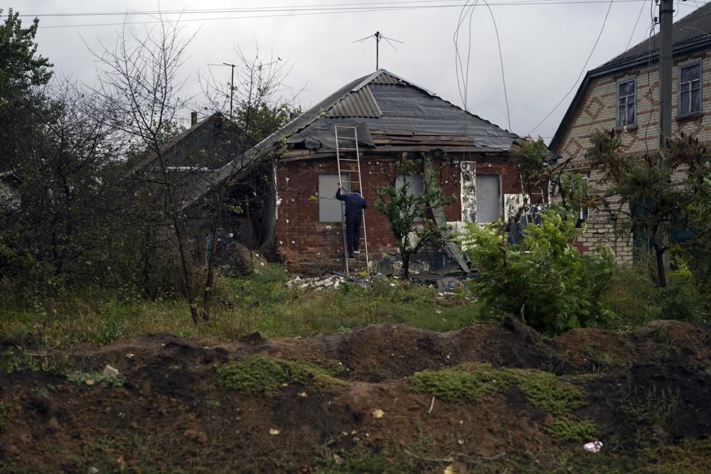 烏克蘭哈爾科夫地區一條村的戰壕前，一名男子在工作。AP