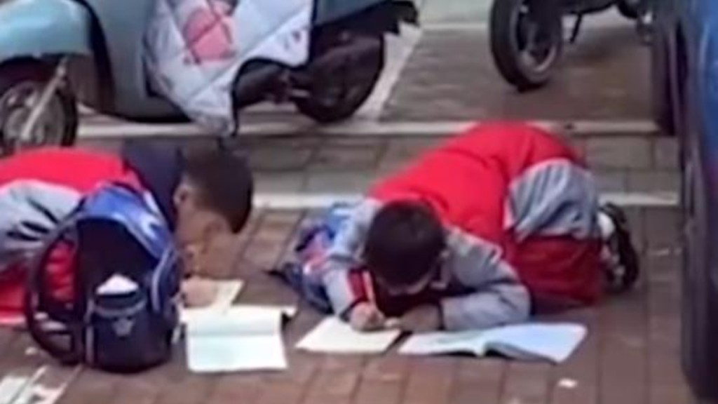 长假结束，杭州有小学设作业缓交期。图为内地小学生在校门外赶做功课。网络图片