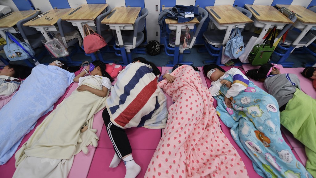 杭州市一所学校的五年级学生在教室内午睡。 中新社