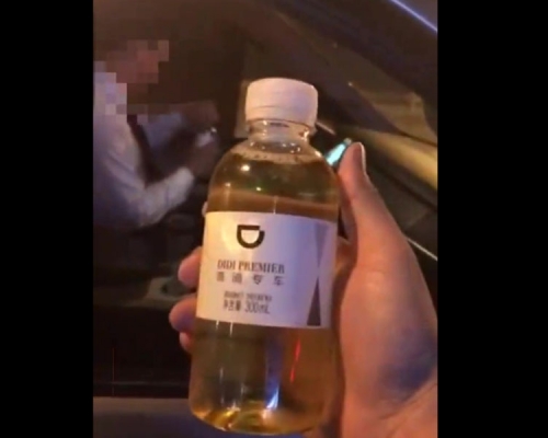 孫先生拿着「尿水」質問涉事滴滴司機。(網圖)