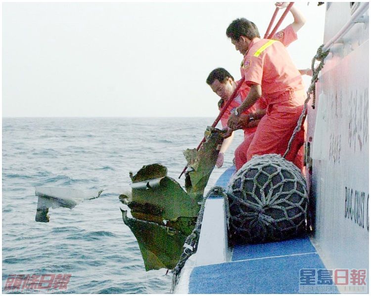 台灣海巡署人員在海上撈起飛機碎片。資料圖片