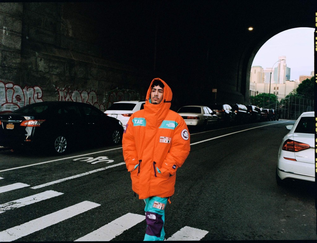 TAE穿越南极州复刻系列橙色大衣/$6,990/TF，背幅缀以不同的徽章装饰。