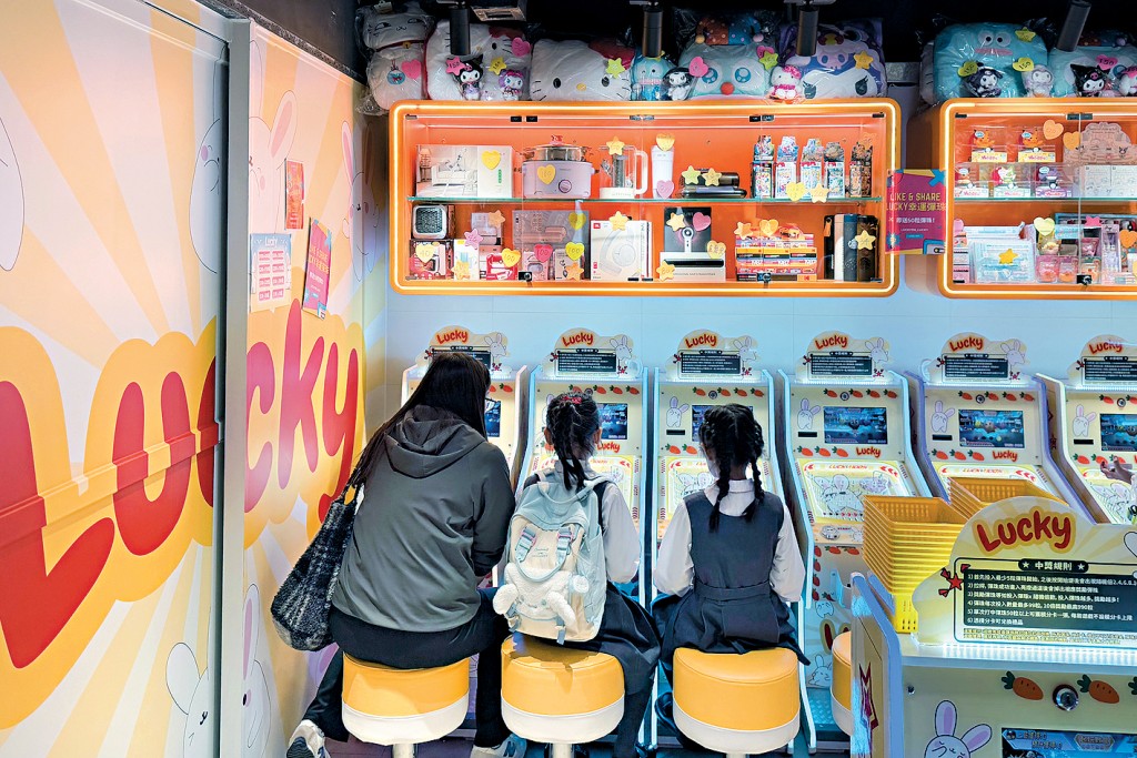 有媽媽帶着兩名小朋友一起光顧彈珠機店。