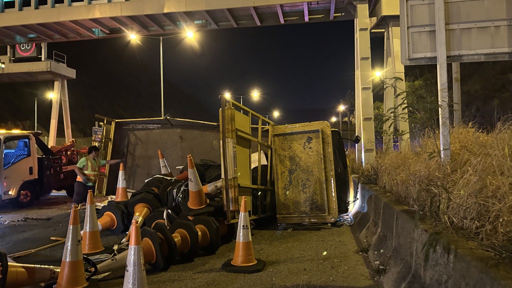 箭嘴工程車向右翻側，大量「雪糕筒」散落一地。蔡楚輝攝