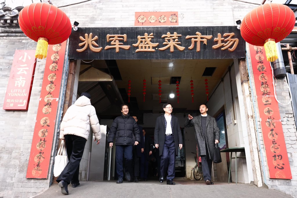行政長官李家超上京期間，警司莊漢麒（右一）陪同到北京老胡同胡同菜市場參觀。(李家超FB)