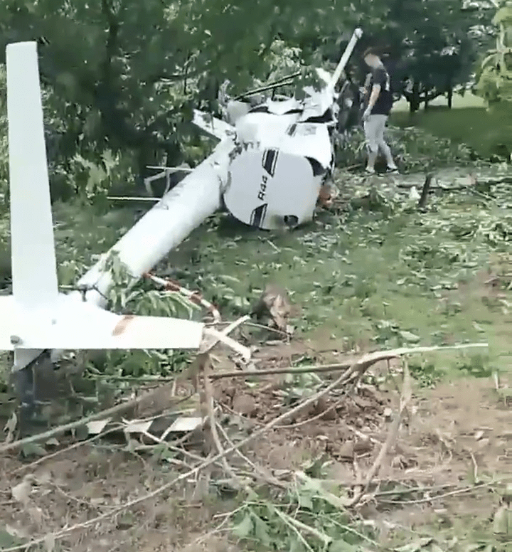 曝光的現場畫面顯示，在一處小樹林裡，一架白色的小型直升飛機的機身墜毀在樹林裡。