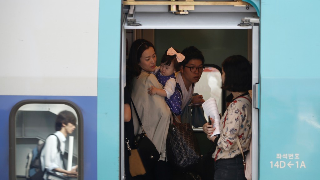 南韩民众在中秋节假期带孩子回老家探亲。 路透社