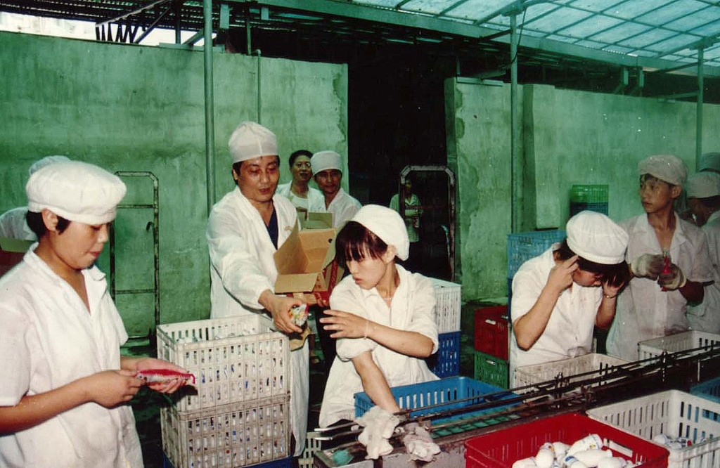 宗庆后中年创业，终成中国首富。图为年青时宗庆后（左二)向员工递雪条。新华社