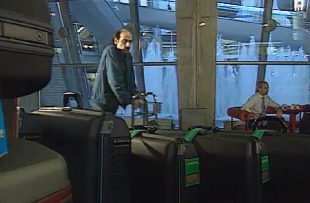 纳赛里推著装满家当的手推车在机场游走。网图
