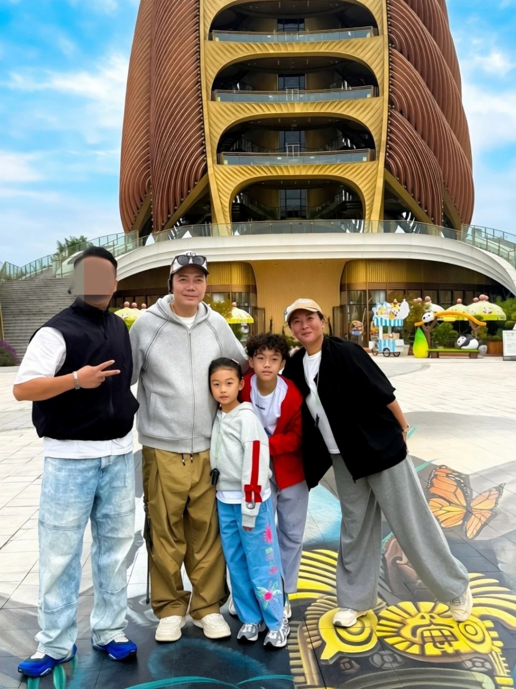 近日謝天華一家四口去旅行，於成都地標建築前溫馨同框，一對仔女高度已直逼父母。