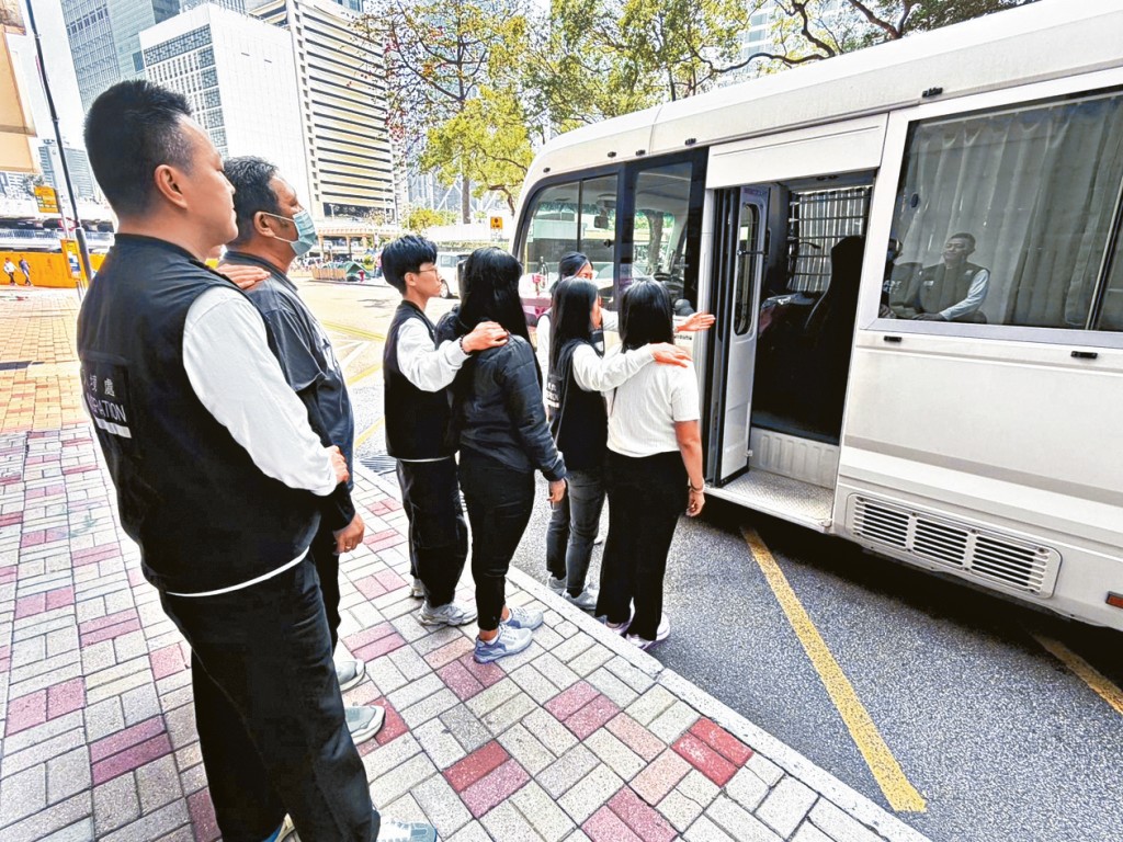 入境處人員將被捕的懷疑「黑工」押走。