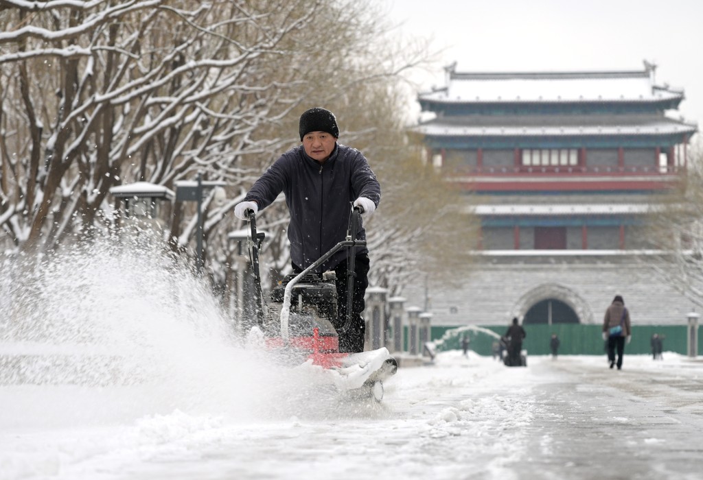 北京已發暴雪橙色預警，民眾正清理道路積雪。新華社