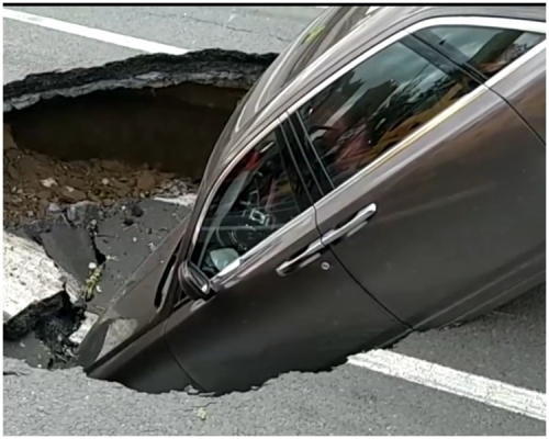 肇事私家车半身倾斜陷入洞中。网上图片