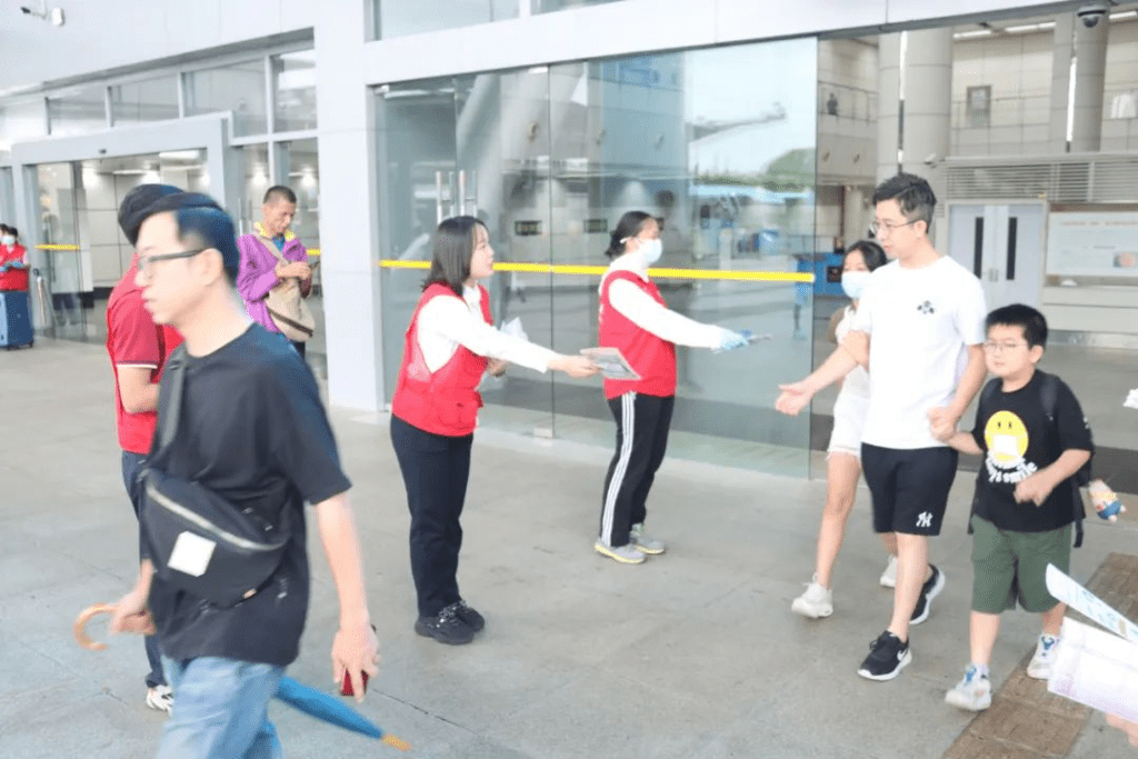 有義工向旅客派發深圳旅遊攻略小冊子。