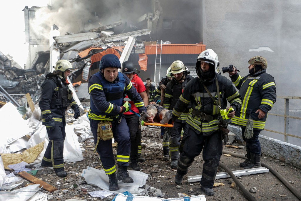 消防員從火場抬出死傷者。路透社