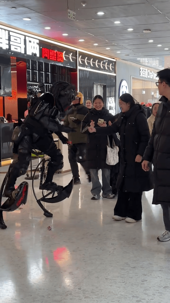 周高賽穿上機甲「戰衣」與民眾猜拳。 抖音