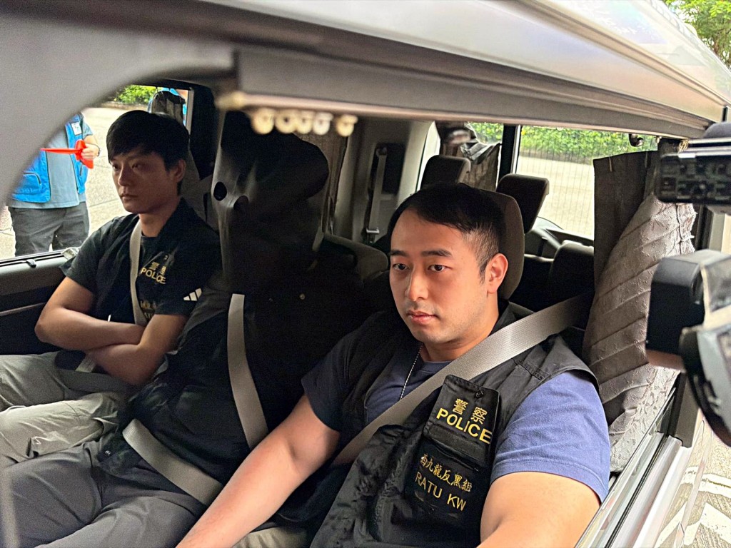 探員押解黑布蒙頭的「左口」。曾志恆攝 探員押解黑布蒙頭的「左口」。曾志恆攝