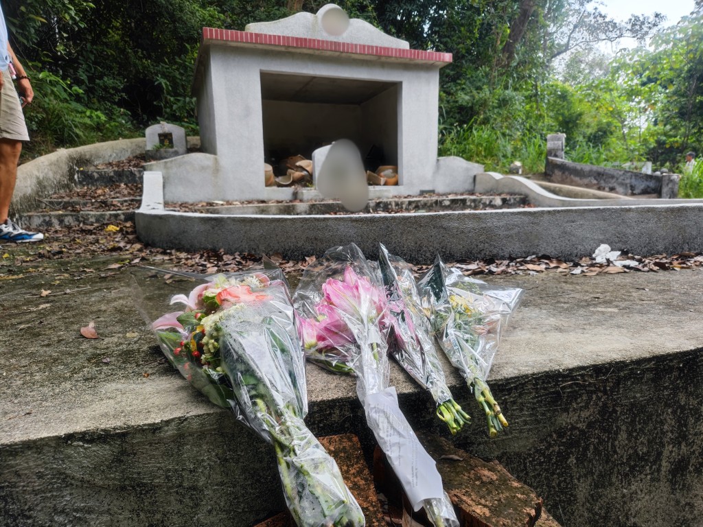 坟头前放有鲜花，相信后人今晨前来拜祭时发现金塔被毁。