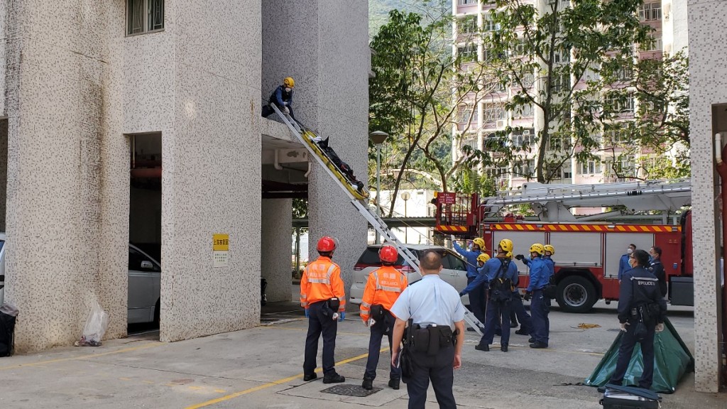 消防用钢梯将女子尸体移往地面。杨伟亨摄