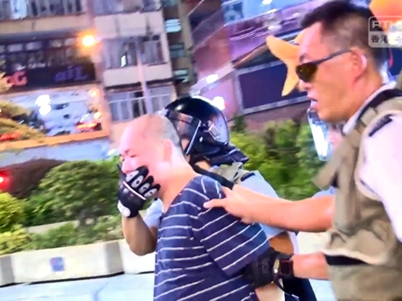 被告當日被警方拘捕帶走。港台影片截圖