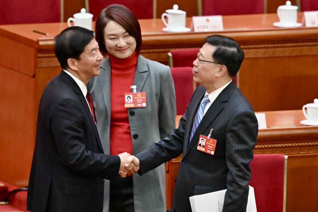 駱惠寧於會後走到台前，與李家超打招呼。