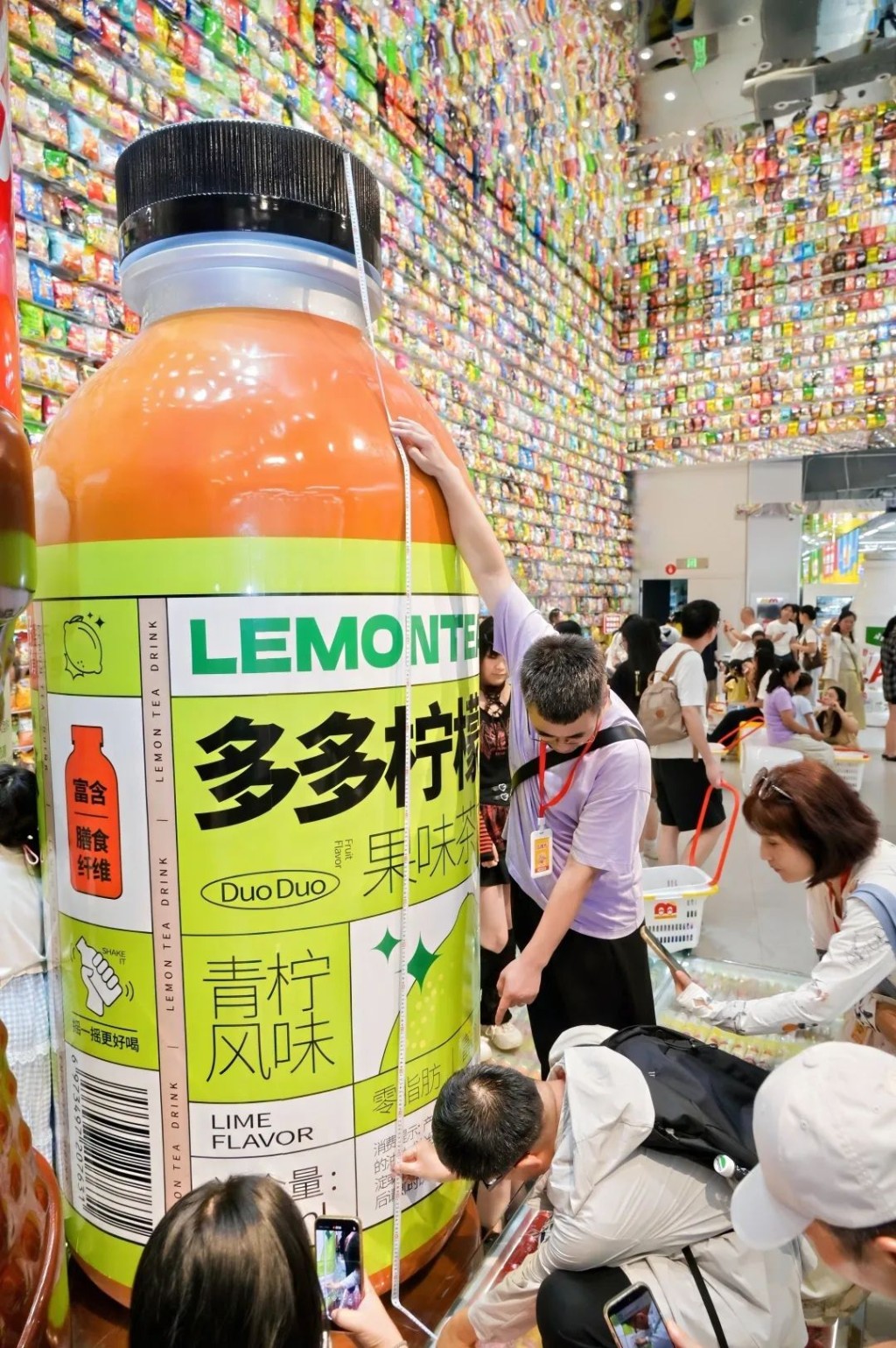 嘉賓拿尺子測量零食王國巨型零食模型。圖:《瀟湘晨報》 嘉賓拿尺子測量零食王國巨型零食模型。圖:《瀟湘晨報》