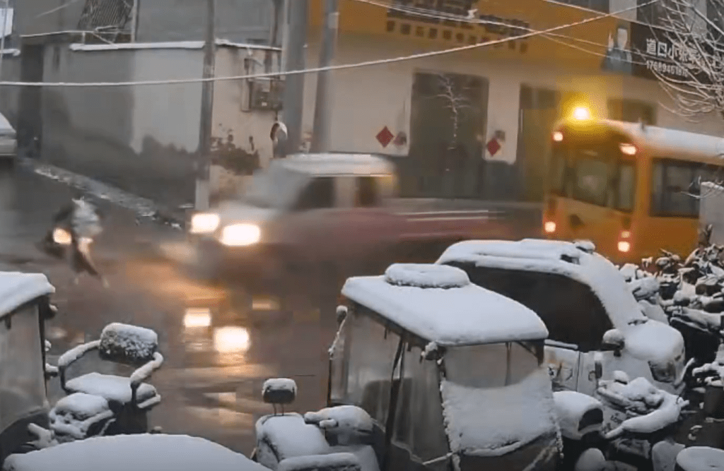 男童過馬路時,一輛小貨車從校車對線駛出,撞向男童。 男童過馬路時,一輛小貨車從校車對線駛出,撞向男童。