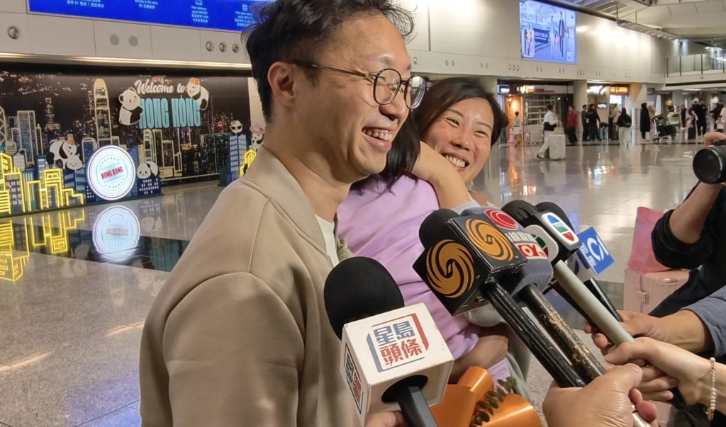 在阿联酋工作的张先生，抢到今日返港航班，妻子和女儿带同鲜花到机场接机，场面温馨。