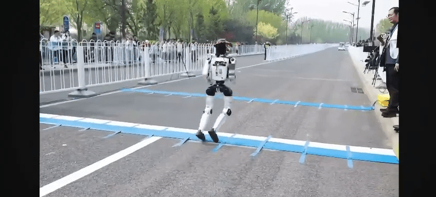 北京人形機械人半馬賽前測試，在起跑線上絆倒。