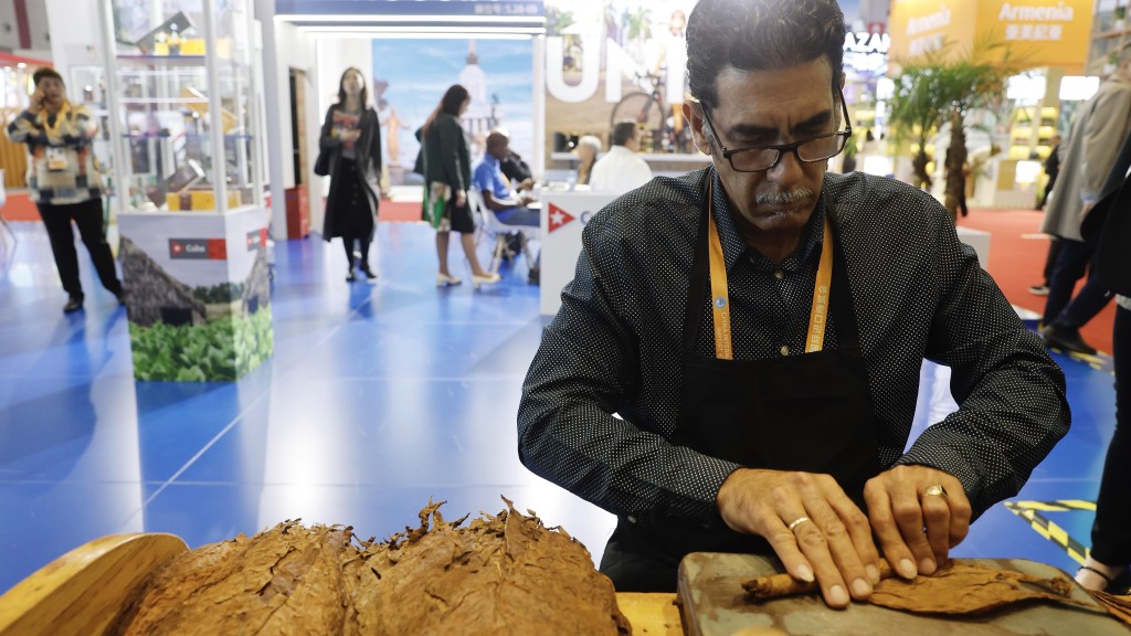 工作人員在上海進博會展示手工製作雪茄。 中新社