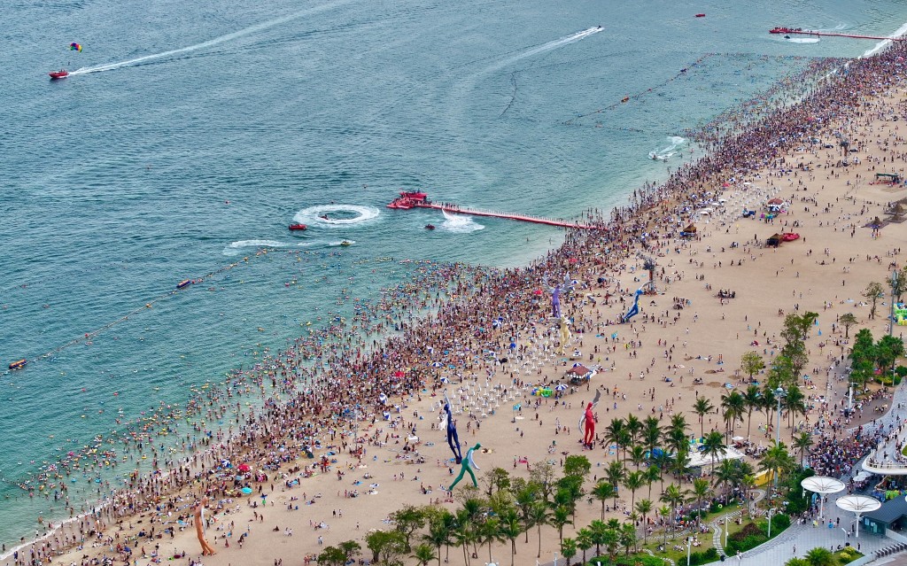 游客汇聚深圳大梅沙海滨公园浴场避暑，单日人流量高峰达11万人次。 中新社