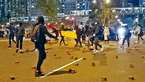 黑衣人在唐明街一帶用磚頭及雜物堵路。