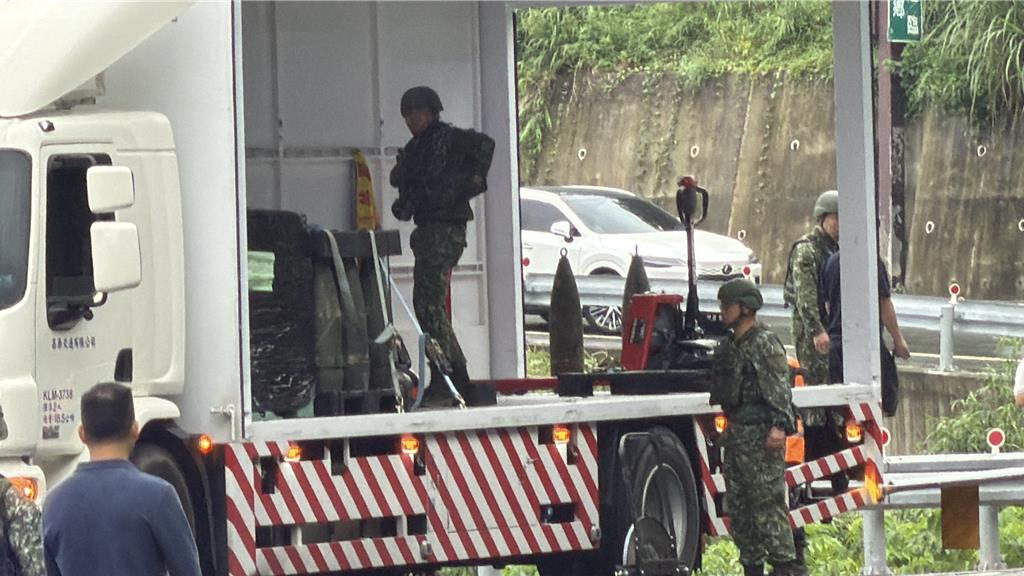 台灣軍方將跌出卡車的8寸榴彈回收。中時