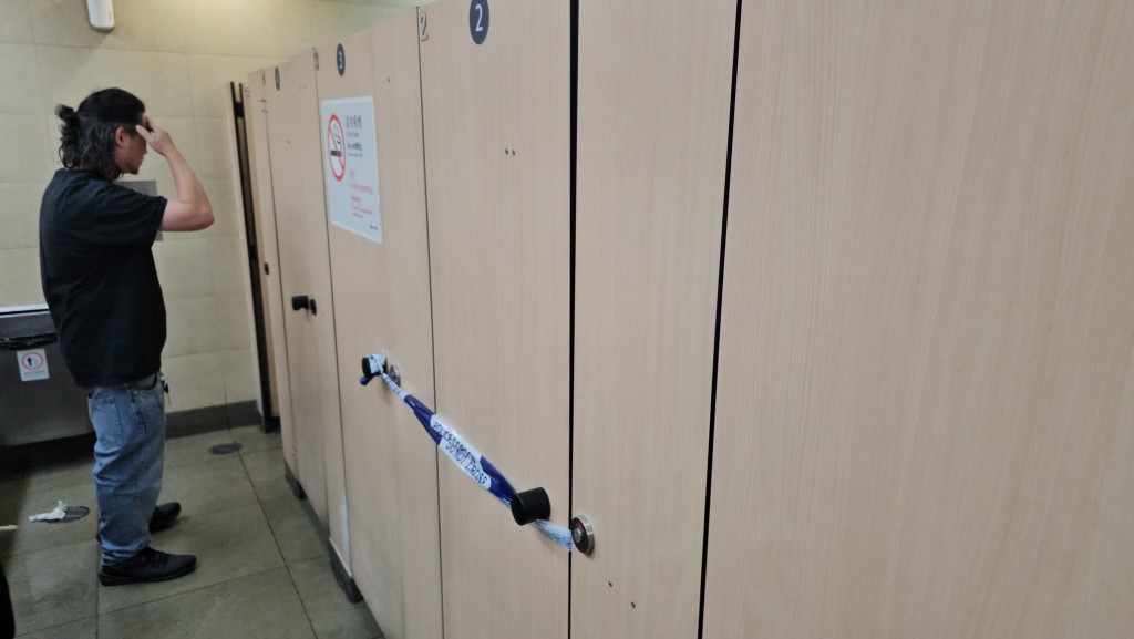 男厕其中一个厕格门后贴有一张A4大小的纸张，上面写有他人的个人资料。