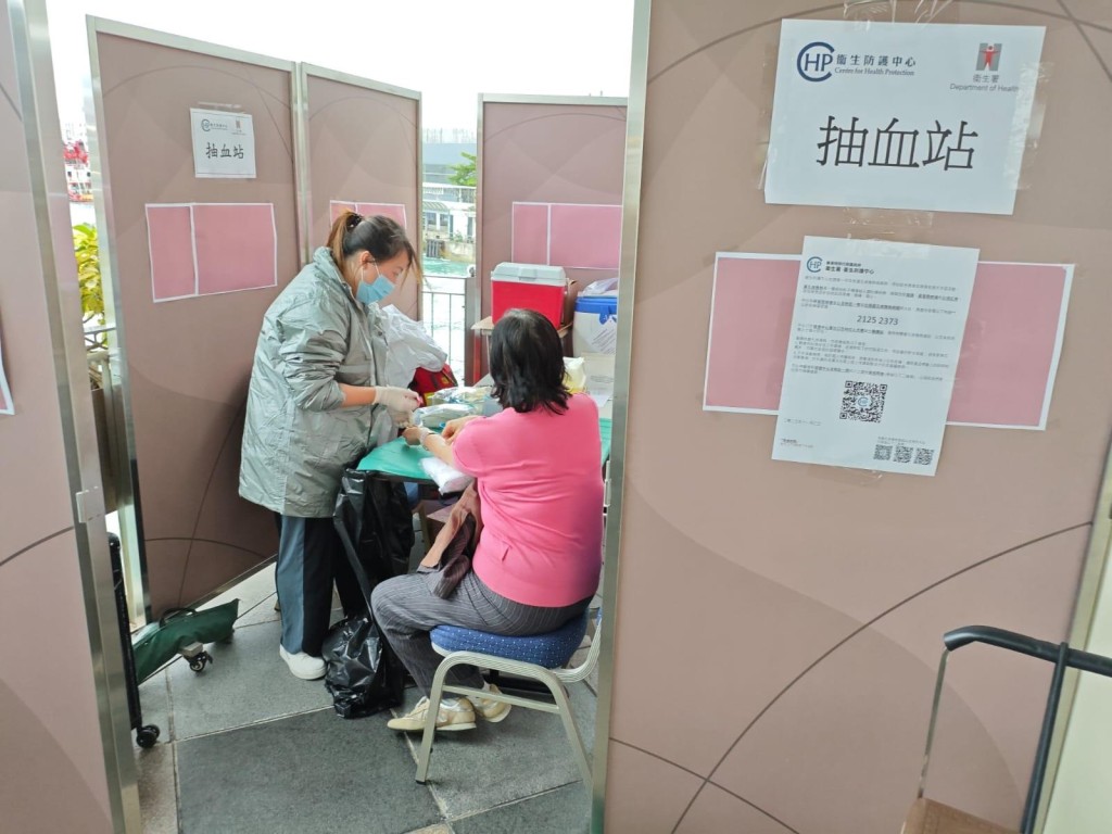 中心人員(左)在上環信德中心一帶的醫護站,為出現相關症狀的當區居民進行抽血檢查。 中心人員(左)在上環信德中心一帶的醫護站,為出現相關症狀的當區居民進行抽血檢查。