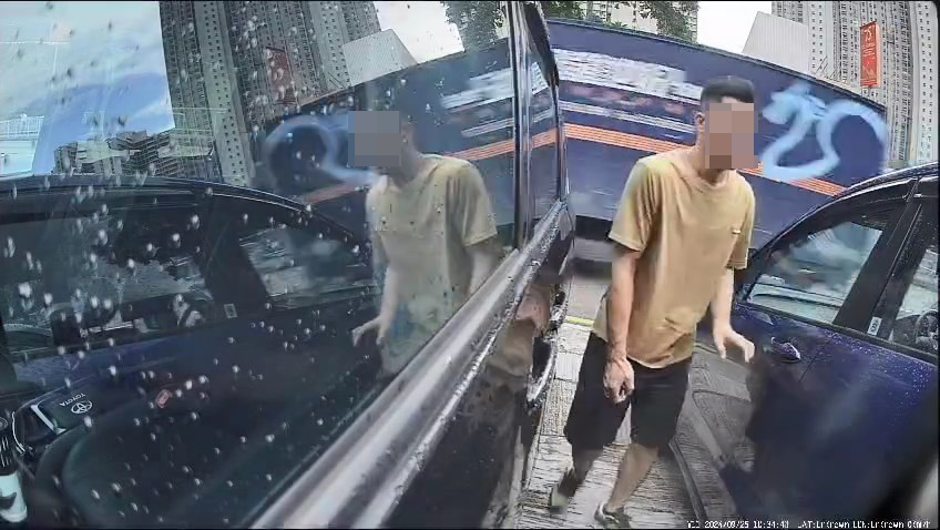 一名中年男子日前走入兩車之間的車罅。網上片段截圖