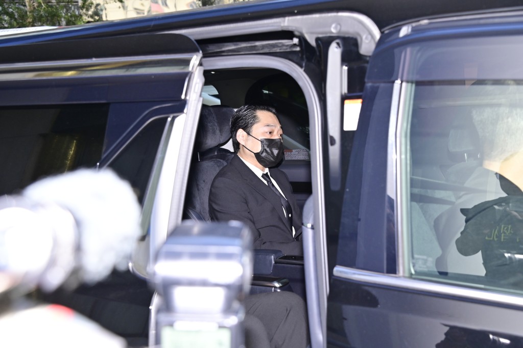 許智政乘坐黑色七人車，與靈車齊齊駛離殯儀館。