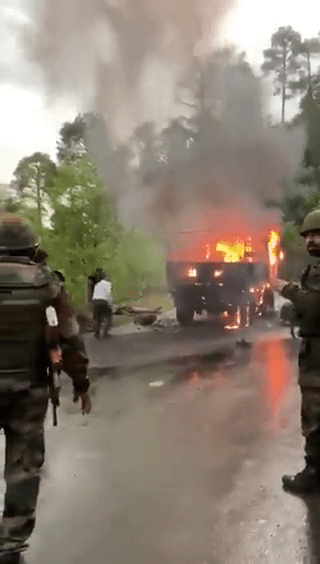 印軍車遭投手榴彈起火，在馬路上冒出大量濃煙。網片截圖
