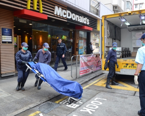 仵工將遺體舁送殮房。 歐陽偉光攝