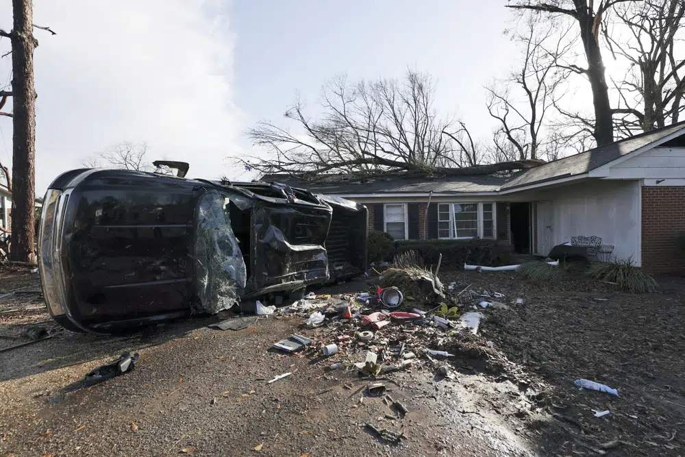 阿拉巴马州塞尔玛，在一所小学附近受龙卷风吹袭后，车辆被吹倒，碎片散落。AP