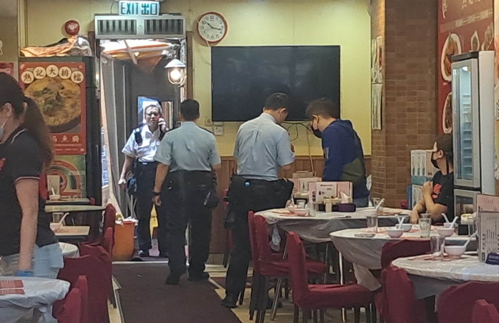 警员在食店向负责人调查。