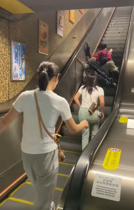 熱心市民走上扶手梯協助。