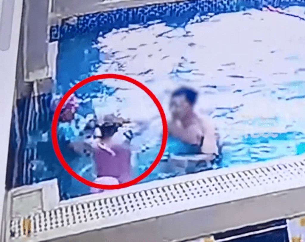 女童頭部被按落水後，站起來移正泳帽。