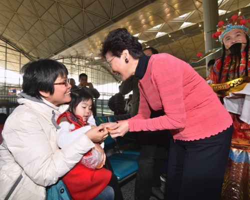 林鄭月娥在機場向市民及旅客拜年,並派朱古力及合照。新聞處