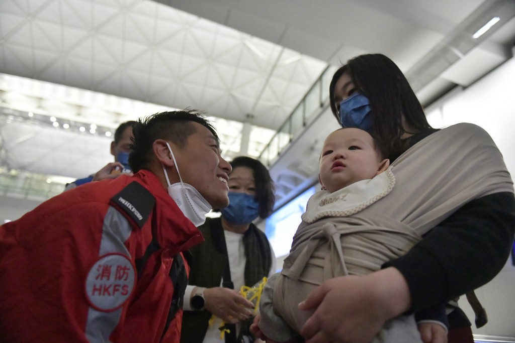 救援队队员刘文发由太太带手抱儿子接机。陈极彰摄