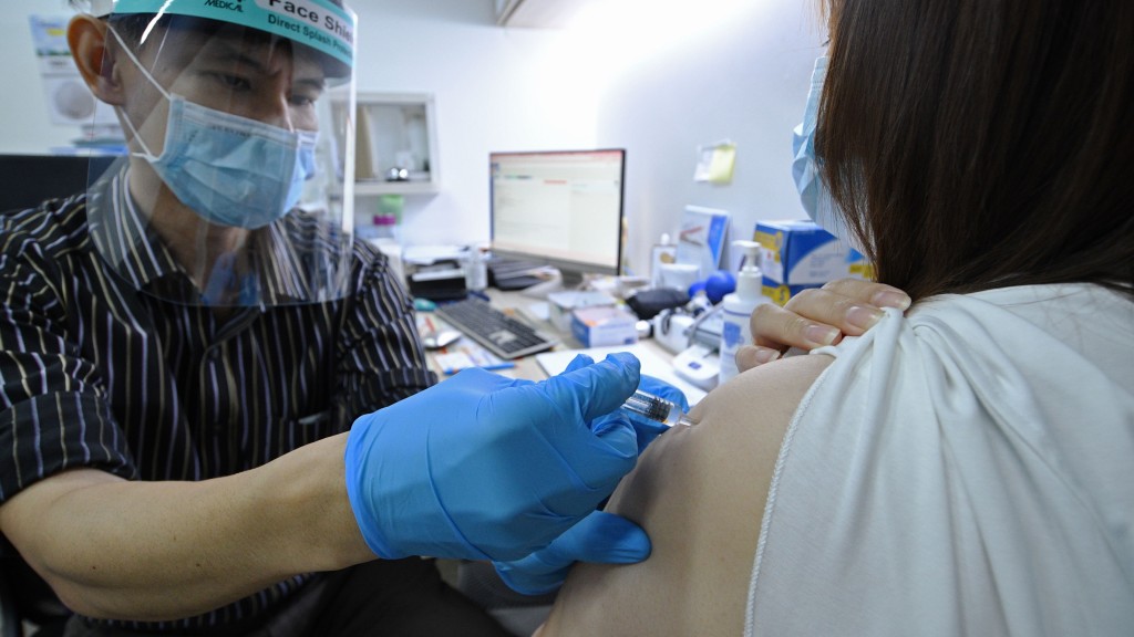 新加坡私家醫生為一名女子注射科興疫苗。 新華社
